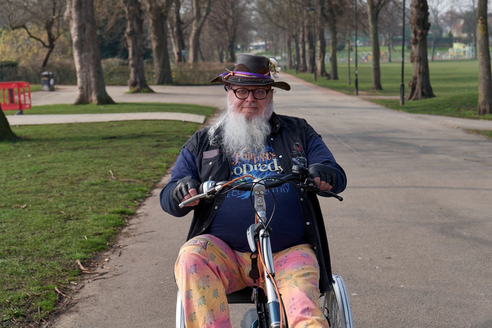 Smiling older man riding his mobility scooter in a park