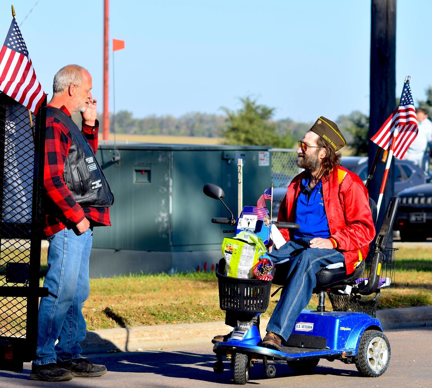 Man riding a red mobility scooter outdoors
